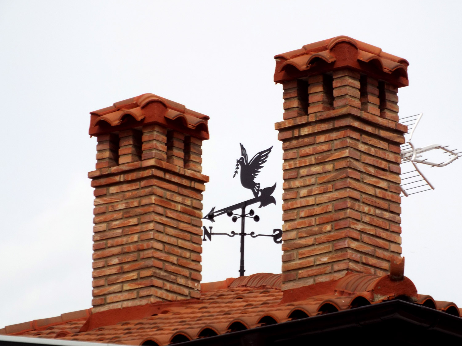 detalle del tejado de la casa con una veleta con forma de paloma